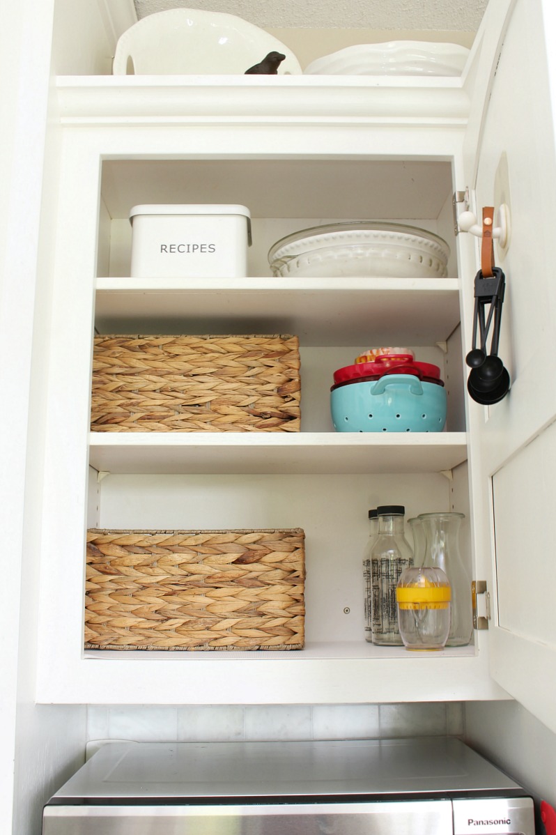 Organized kitchen cabinet with baskets.