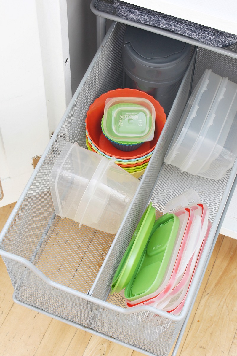 Pull out kitchen organizer drawer to store smaller containers, lids and kids' water bottles.