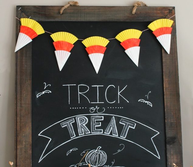 Candy corn bunting made from cupcake liners on a Halloween chalkboard.