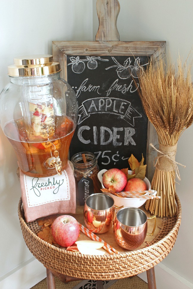 Pretty apple cider beverage bar with a chalkboard sign and decorated with coppers and neutrals.
