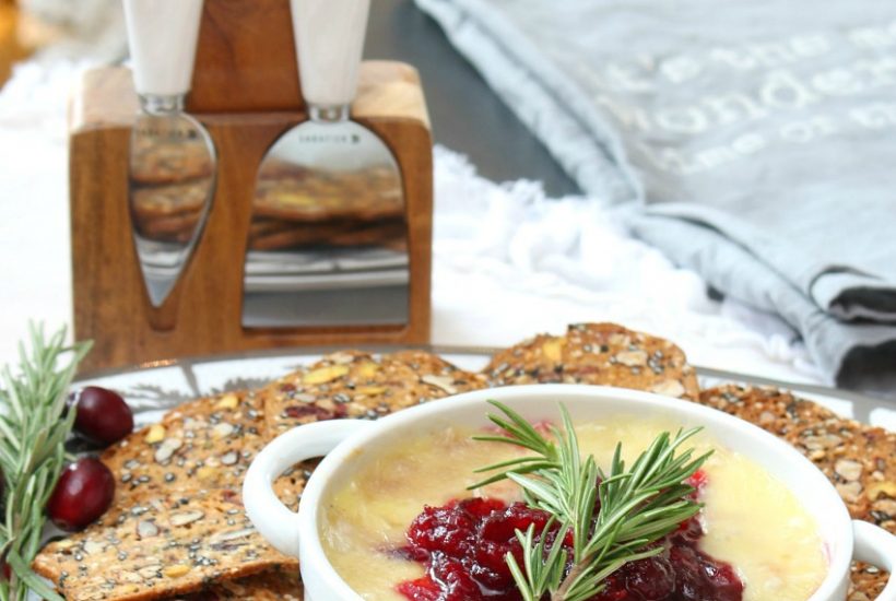 Cranberry baked brie appetizer served with cranberry crackers.