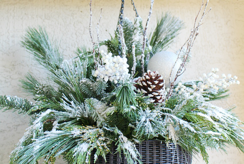 Beautiful Christmas hanging basket with flocked greenery and pinecones.