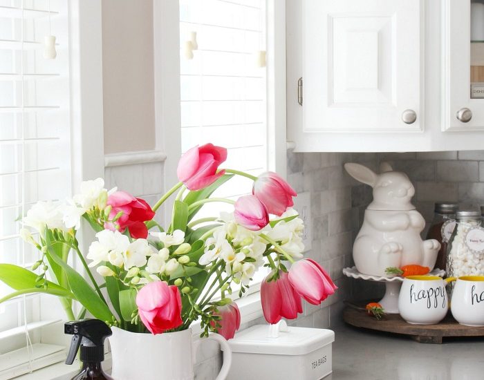 Farmhouse style white kitchen decorated for spring.