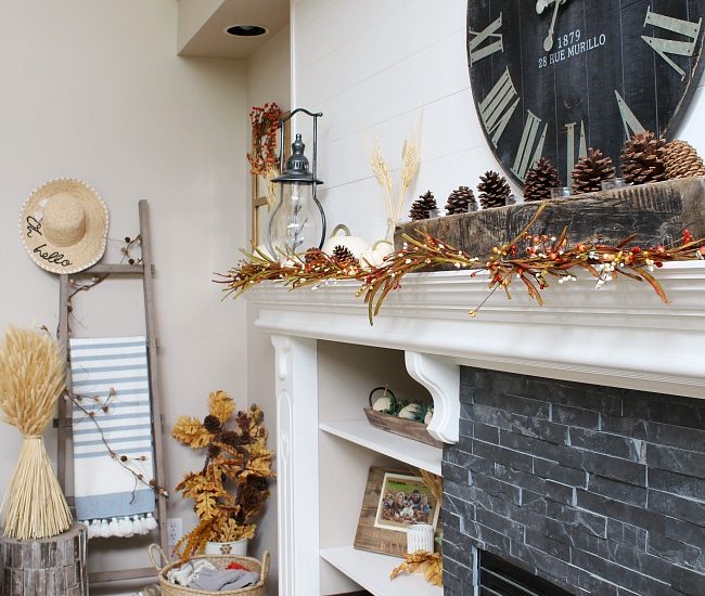 White mantel with faux shiplap decorated for fall. Traditional fall colors, mini-lights and natural elements.