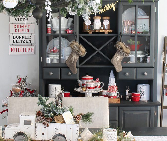 Farmhouse style dining room with black hutch decorated for Christmas in red and white.