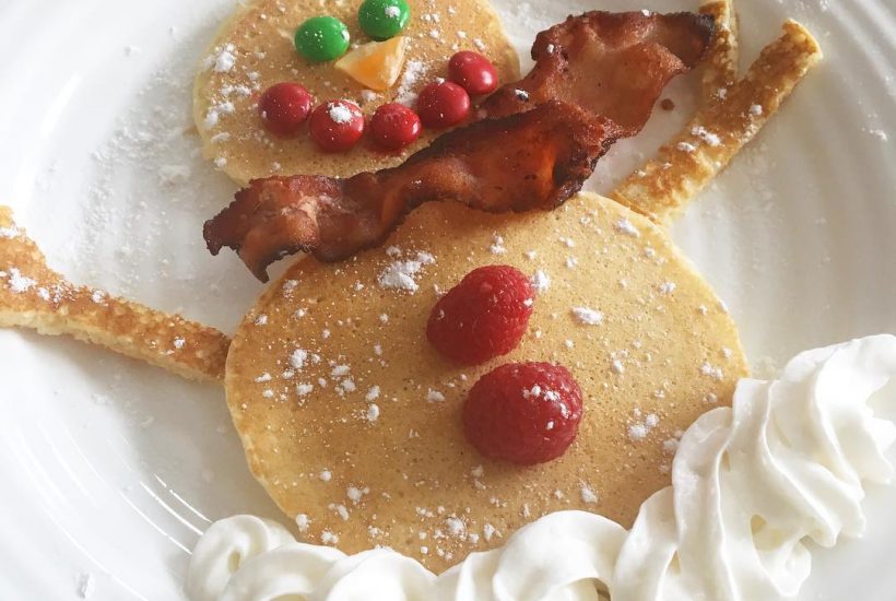 Snowman pancakes with pancakes, bacon, and whipping cream.