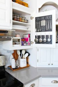 Organized cooking cupboard with chalkboard door and organized spices.