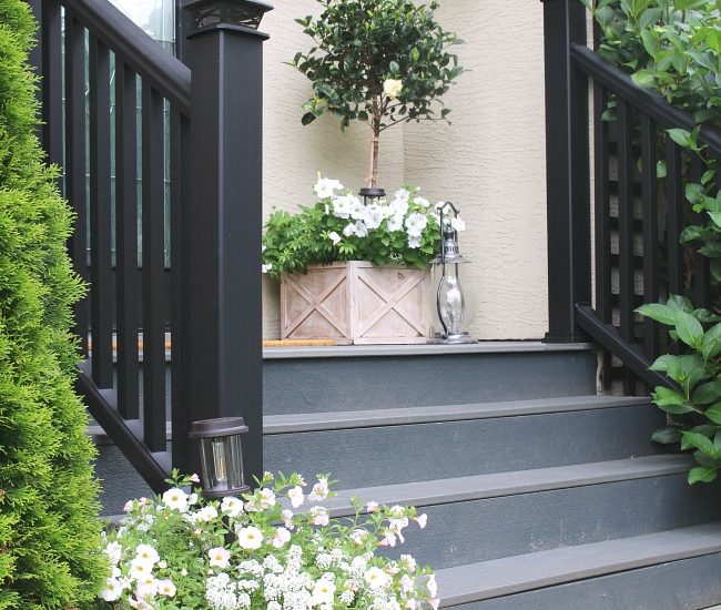 Traditional front porch with a various white flowers.