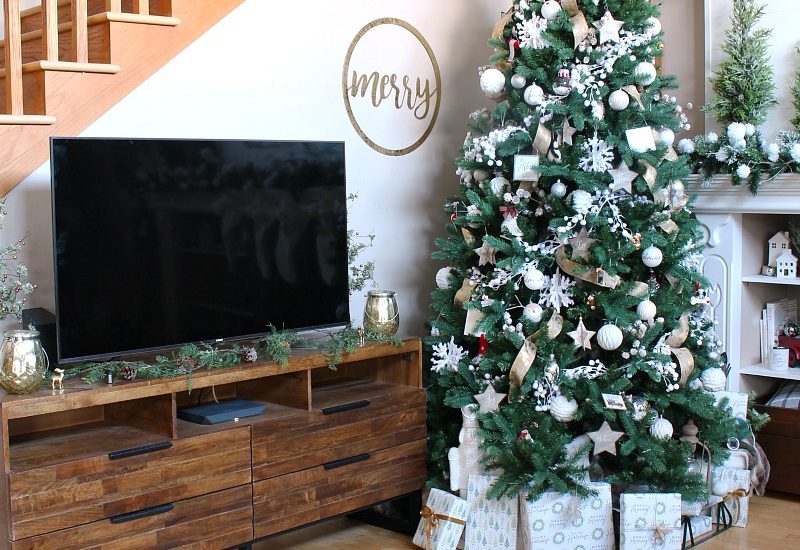 Neutral farmhouse style family room decorated with greens and metallics.