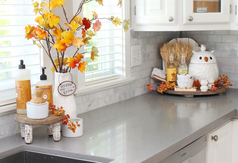 Beautiful farmhouse style white kitchen decorated for fall wth traditional fall colors.