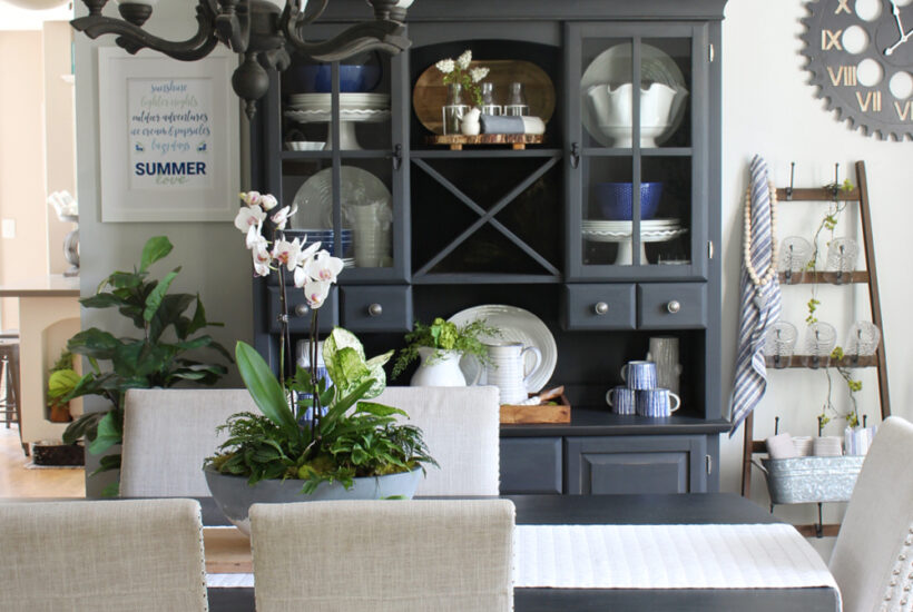 Black hutch and dining room table decorated for summer with blues and greens.