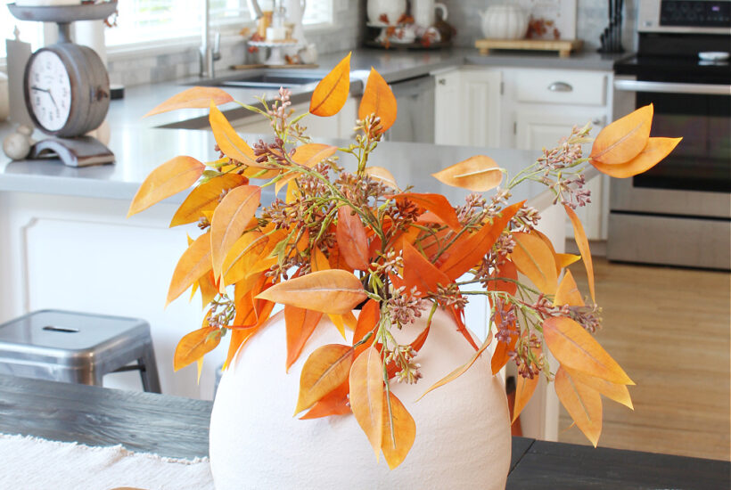 Fall foliage in a white vase for a simple fall centerpiece.