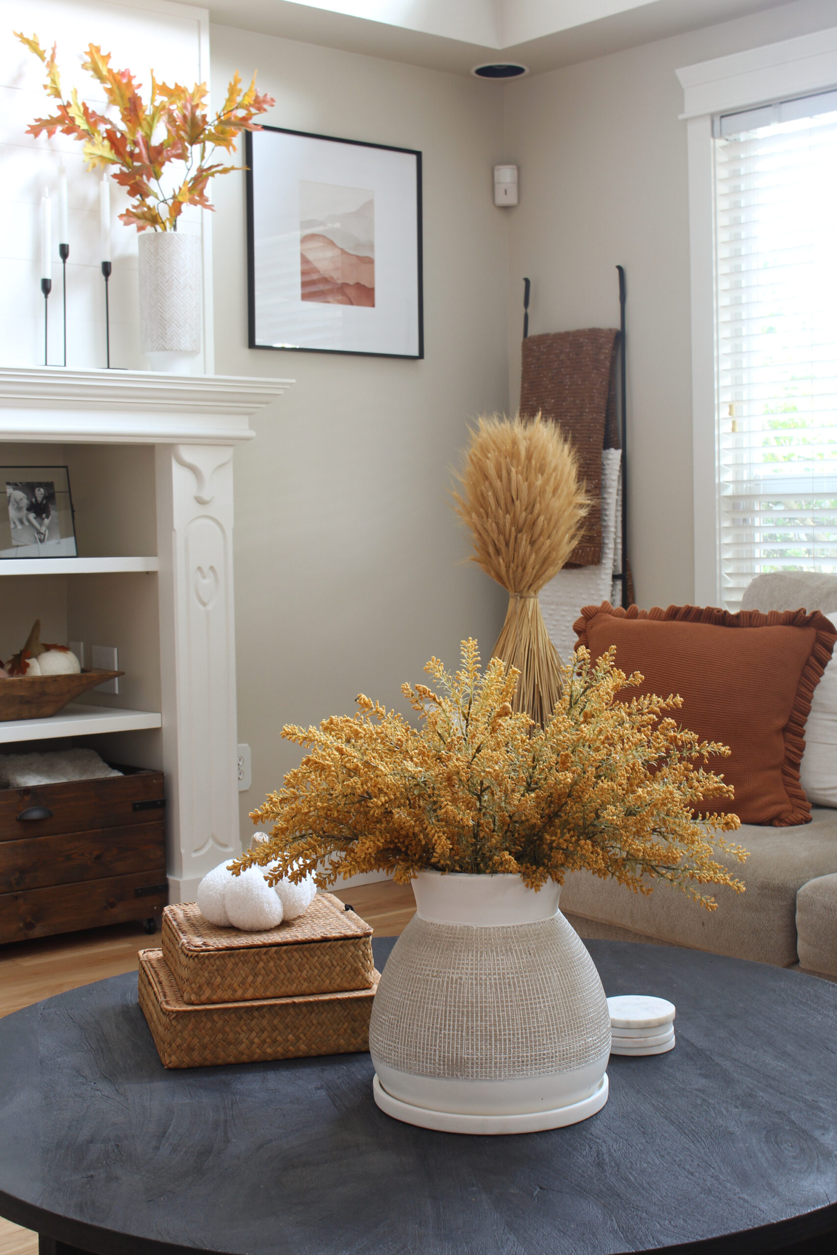 Fall living room with black coffee table with vase and yellow faux stems.