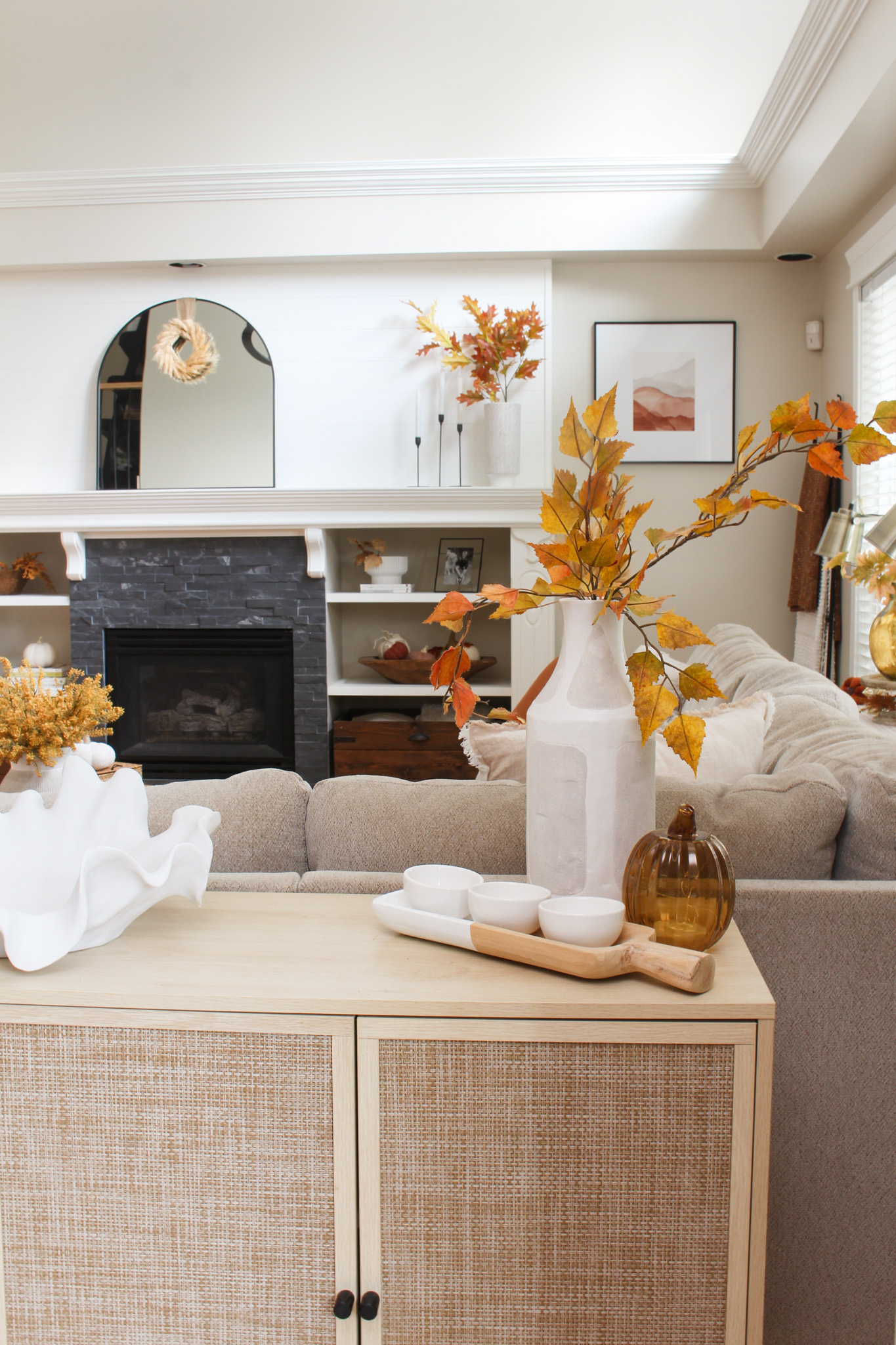 Neutral fall living room decorated for fall with yellows, amber, and rust colors.