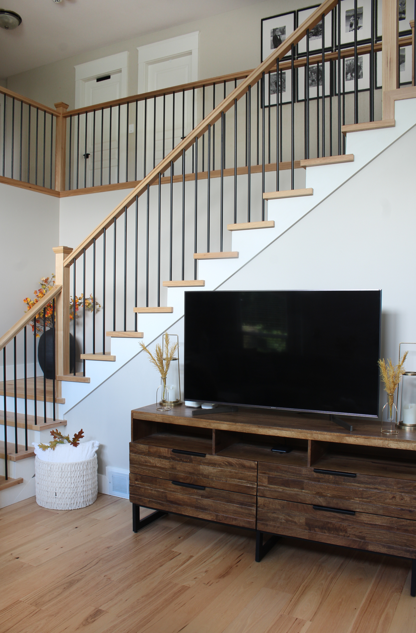 Television stand with subtle fall stems in vases on either side of television.Television stand with subtle fall stems in vases on either side of television.