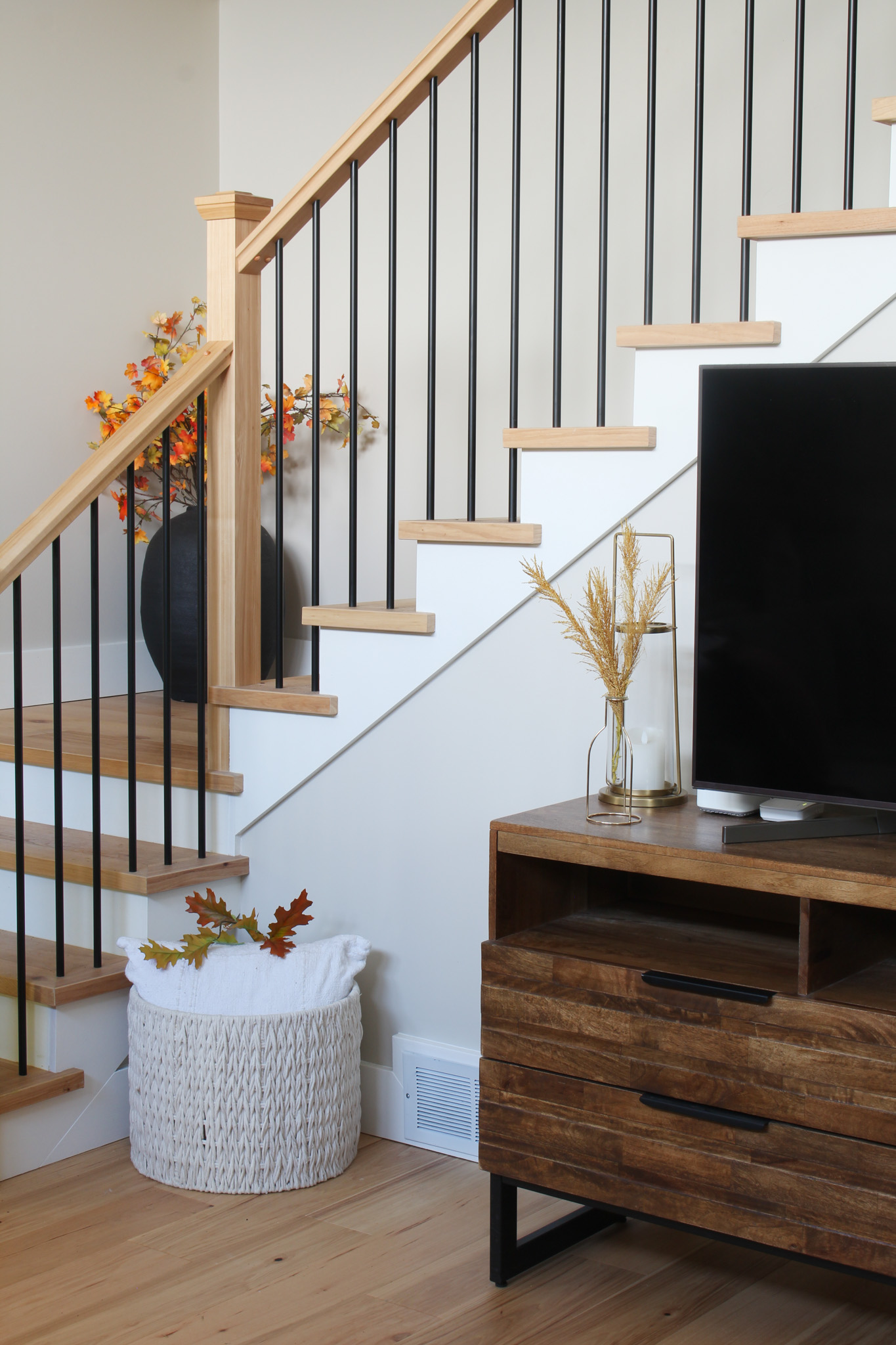 Modern staircase with hickory wood posts and black spindles.