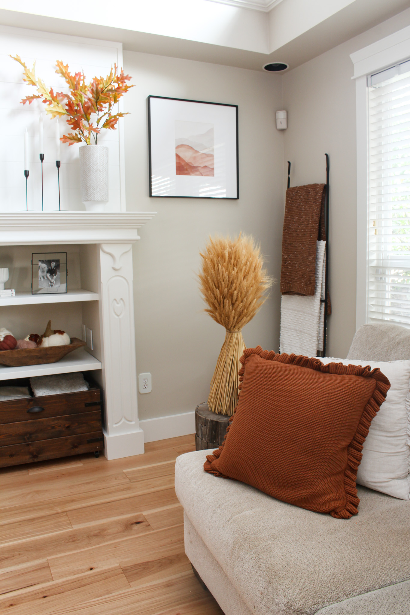 Fall living room with cozy pillows and throws in creams, rust, and browns.