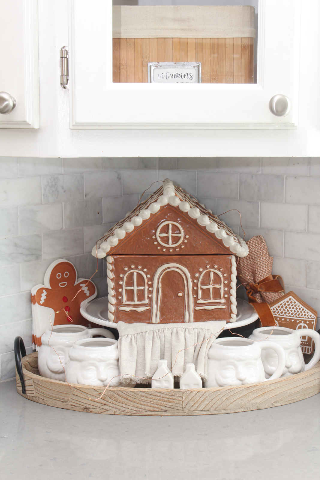 Gingerbread house cookie jar on a cake stand with gingerbread napkins and felt gingerbread house coasters.