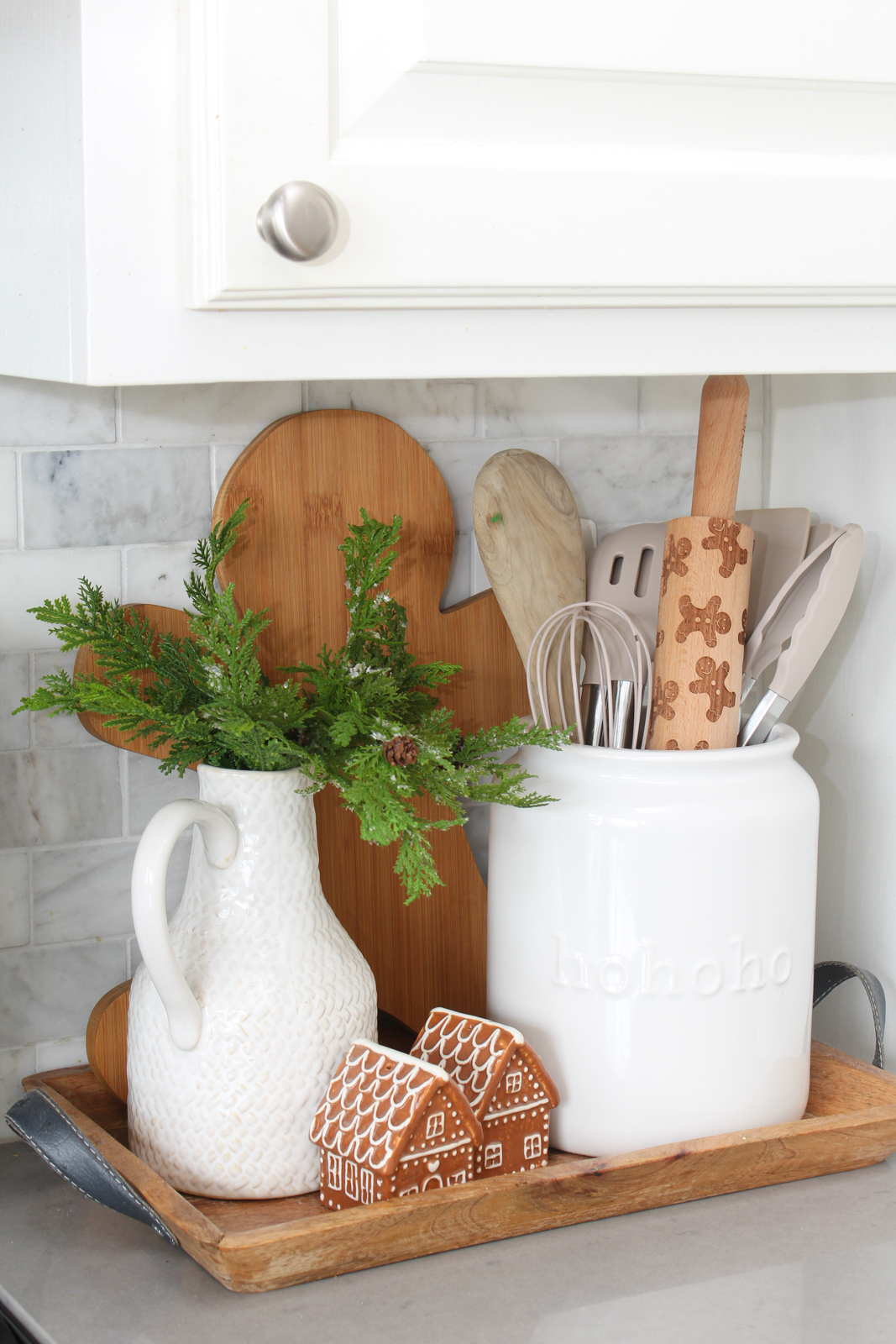 Christmas kitchen utensil tray with gingerbread man cutting board, gingerbread salt and pepper shakers and a gingerbread men rolling pin.