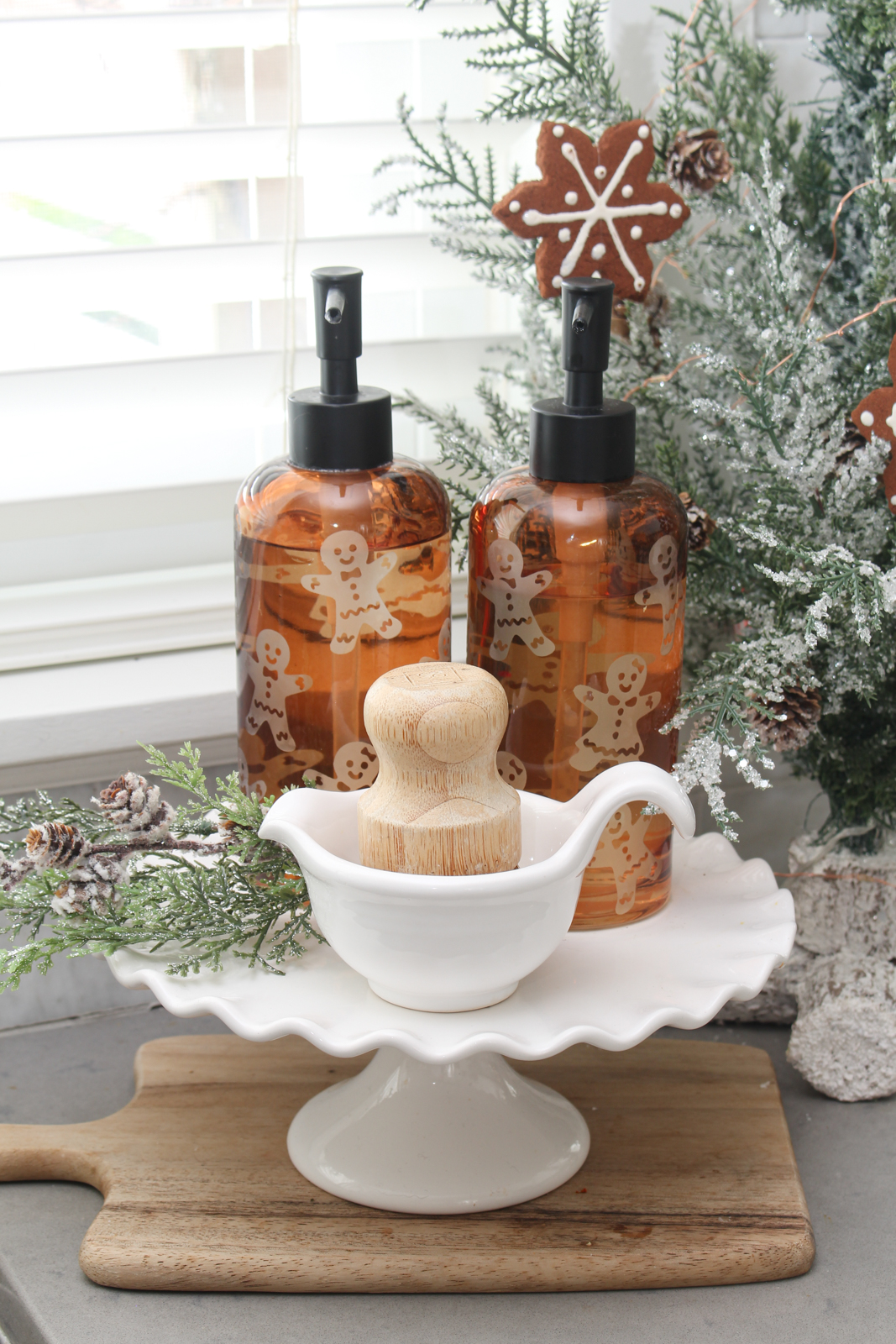 Cake stand with gingerbread men dish soap/hand soap dispensers and scrub brush.