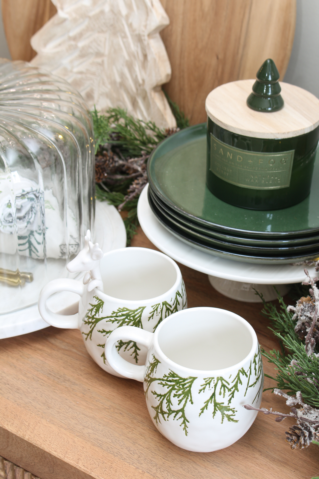 Christmas sideboard decorated for Christmas with green and white serving pieces.