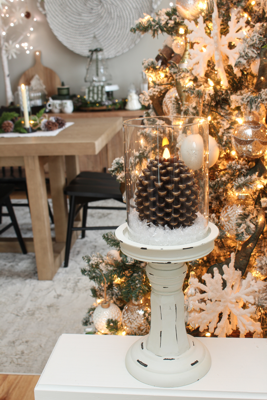 Pine cone battery-operated candle on a wood pedestal. 