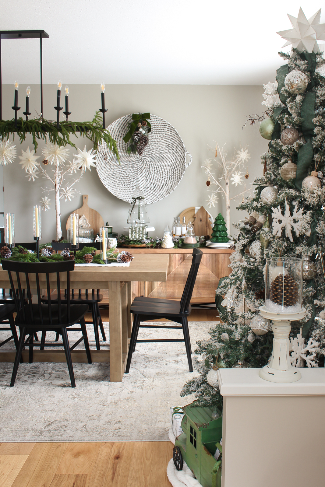 Dining room decorated for Christmas with lots of greenery, pine cones, snowflakes, and other natural elements.